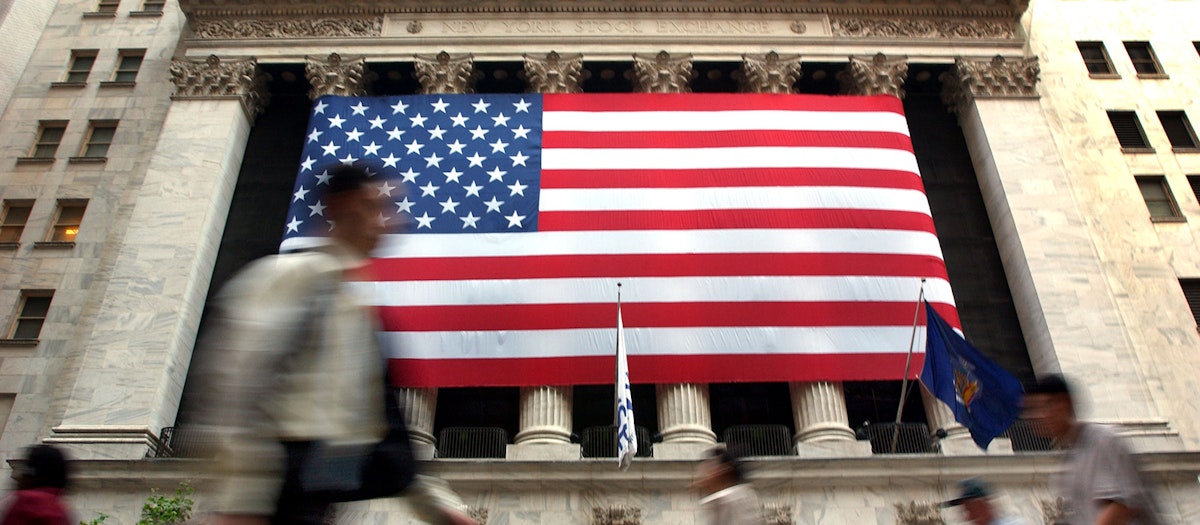 Fast Moving crowd walking by a huge American flag hung outside the New York Stock Exchange