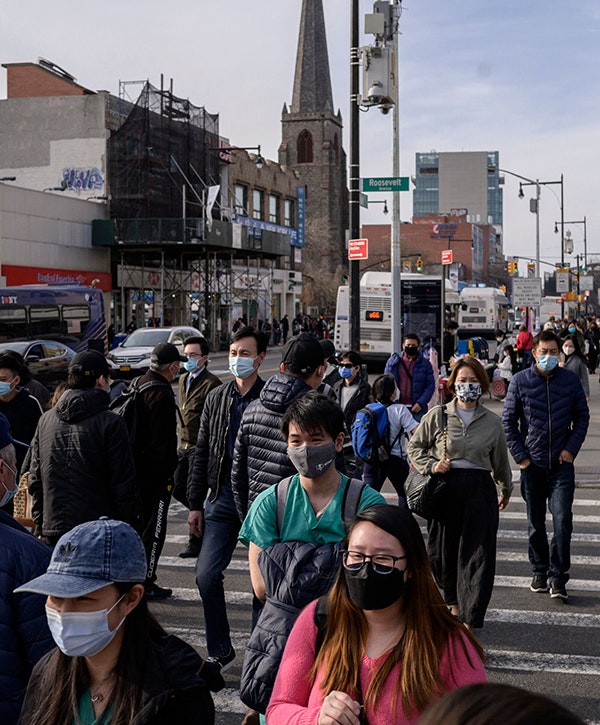 Pedestrians cross a street in Queens, New York on March 23, 2021. (Photo by Ed JONES / AFP) (Photo by ED JONES/AFP via Getty Images)
