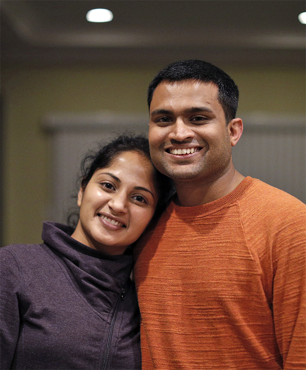 A husband and wife, temporary visa holders stuck in green card backlogs, smile together