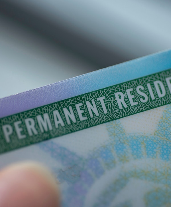 Close up view of Permanent resident card (Green) card of USA on blurred background.