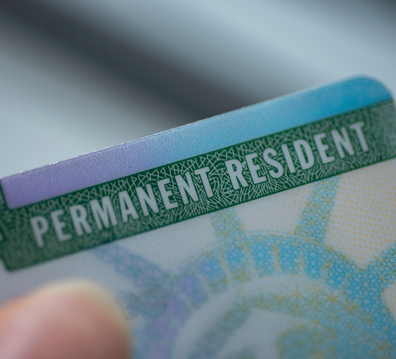 Close up view of Permanent resident card (Green) card of USA on blurred background.