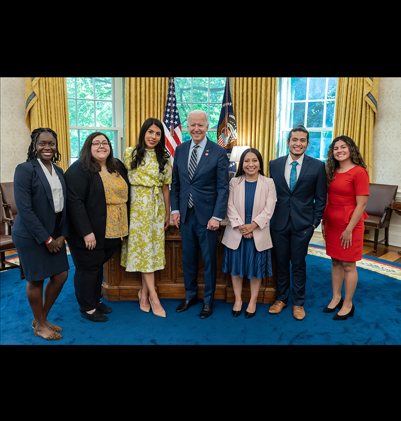 A group of DACA recipients pose for a photo with President Joe Biden during a meeting in the Oval Office of the White House.