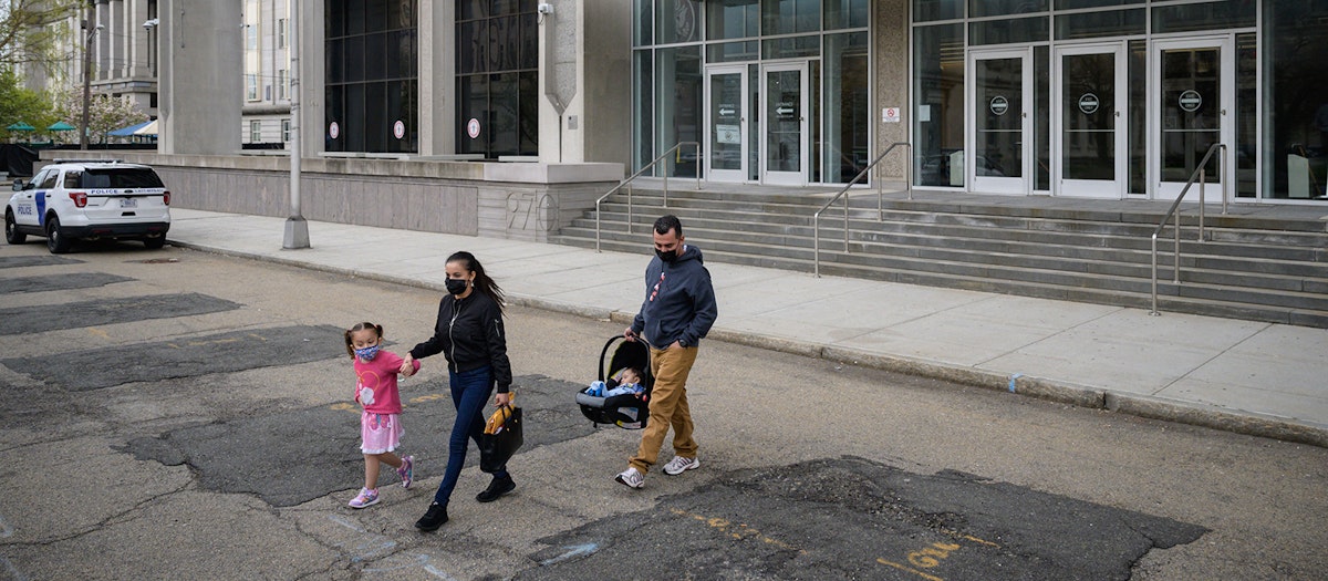 A family (parents and two small children) are seen leaving an Immigration and Customs Enforcement (ICE) office building after an initial check-in.