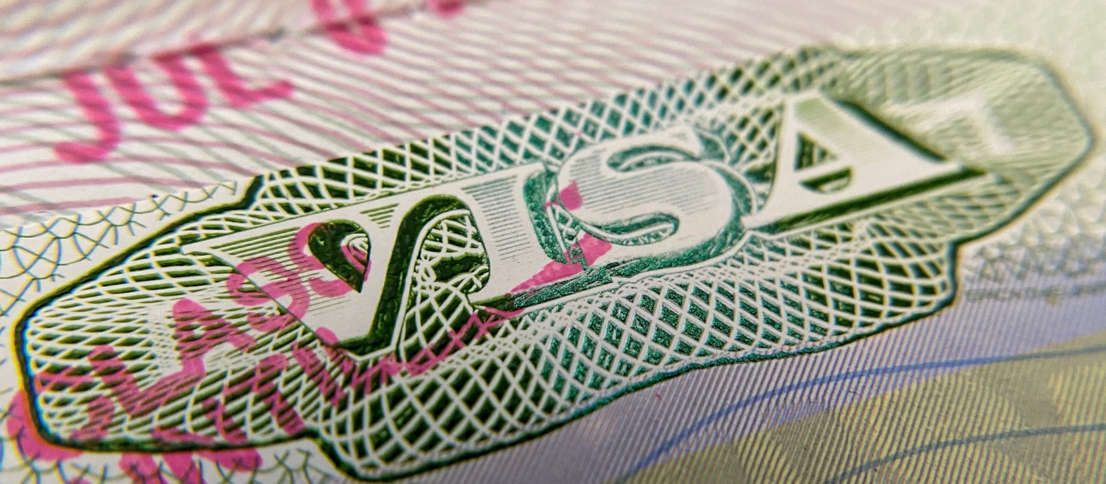 A close-up image of an immigration visa stamped to a foreign passport.