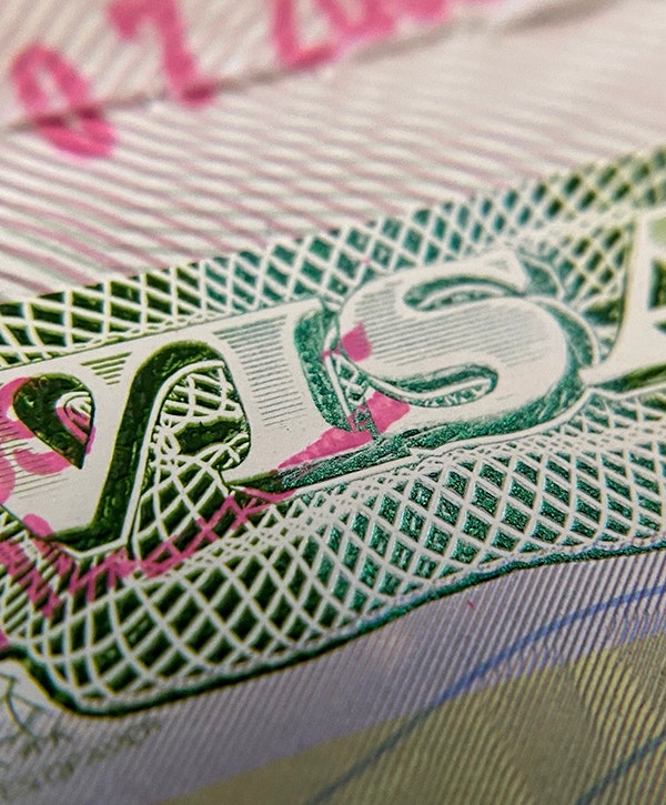 A close-up image of an immigration visa stamped to a foreign passport.