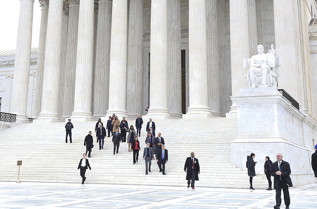 A group of people walks down the steps of the Supreme Court after a hearing on the DACA policy.