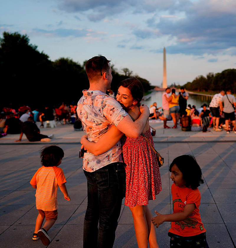 A couple hugs as visitors wait prior to watching the Independence Day fireworks display near the Lincoln Memorial on the National Mall on July 4, 2021 in Washington, DC.